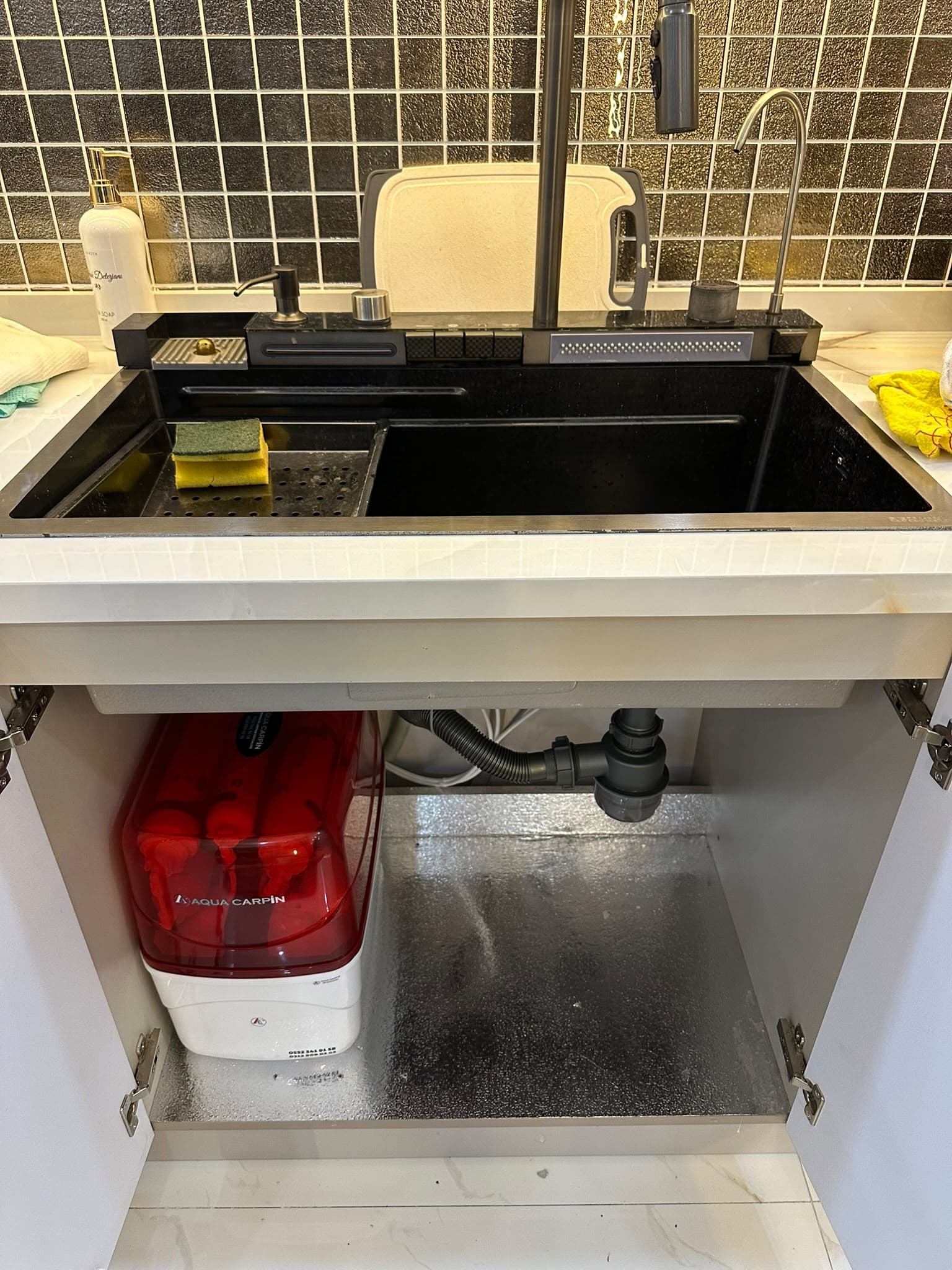 Aqua Carpin water purifier installed under a kitchen counter